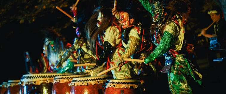 Traditional Kagura dancers performing at night in Buzen